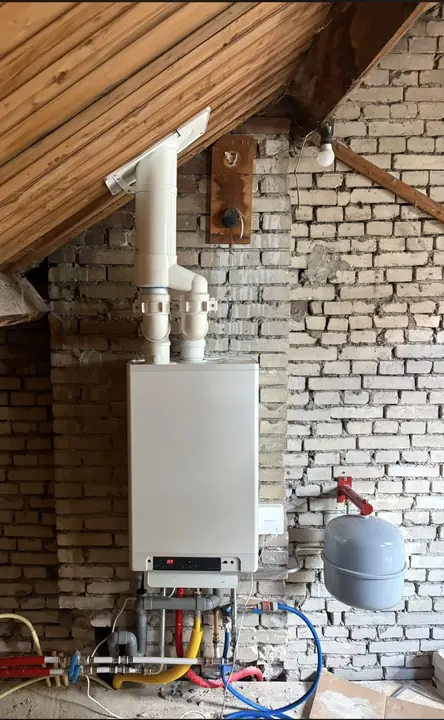 Intergas CW4-cv-ketel op een zolder in Arnhem, met nieuwe rookgasafvoer door het dak